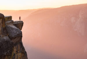 Person enjoys the cliffs at Taft Point at sunset
