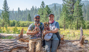 A man and woman with their small dogs posing along the Wawona Meadow Loop Trail